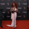 SZA stands with interpreter as she answers questions at the Pre-Grammys